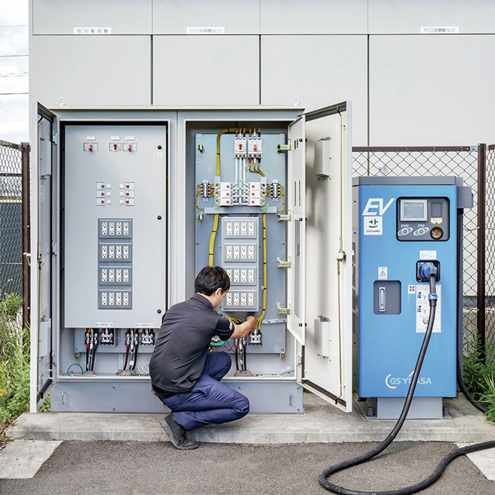 Ichigo engineer Suwabe checking the emergency charging station at the Ichigo Kasaoka Takumicho ECO Power Plant.